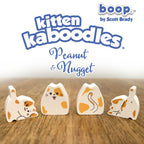 Wooden toy figures of a cat with 'boop' branding on a wooden surface.