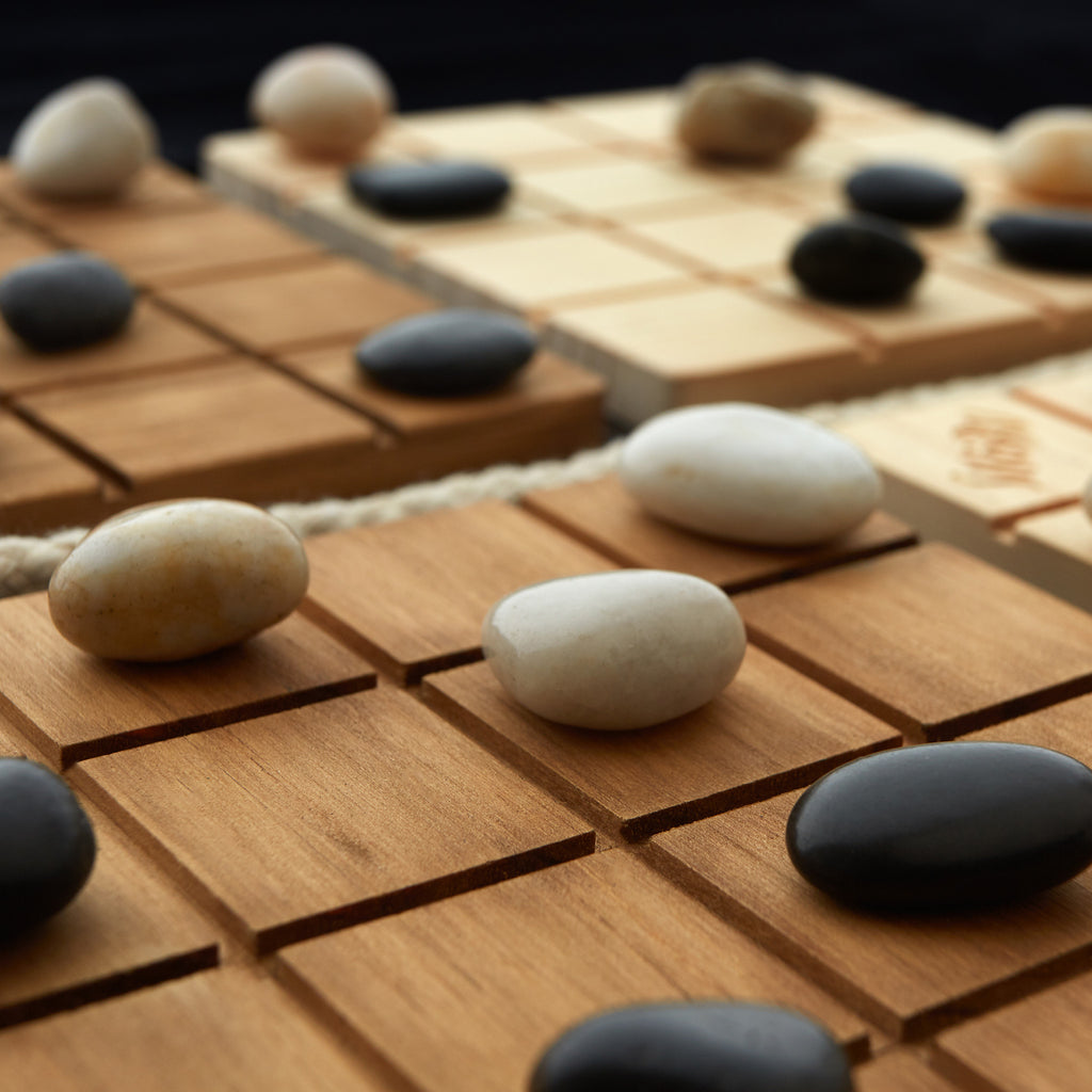 Close-up of a game board with stones on a wooden surface