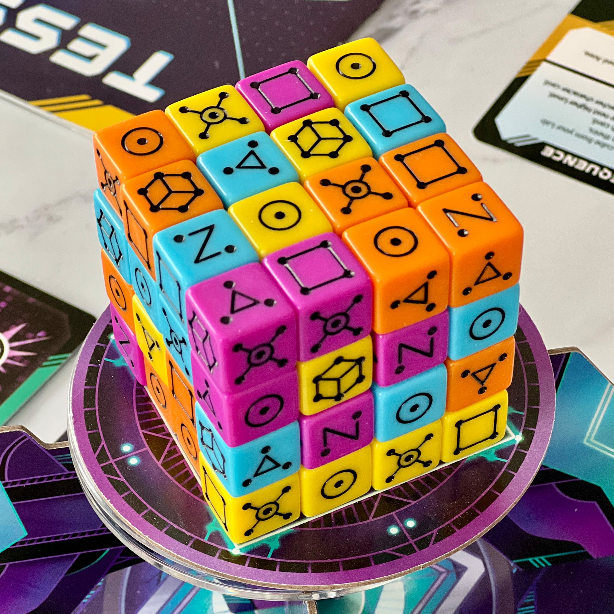 Colorful puzzle cube with symbols on a reflective surface