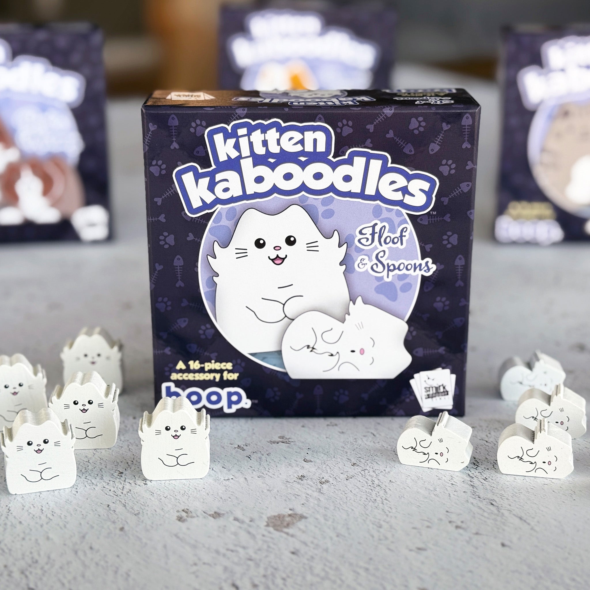 Kitten kaboodles product packaging with cat-themed items on a gray surface