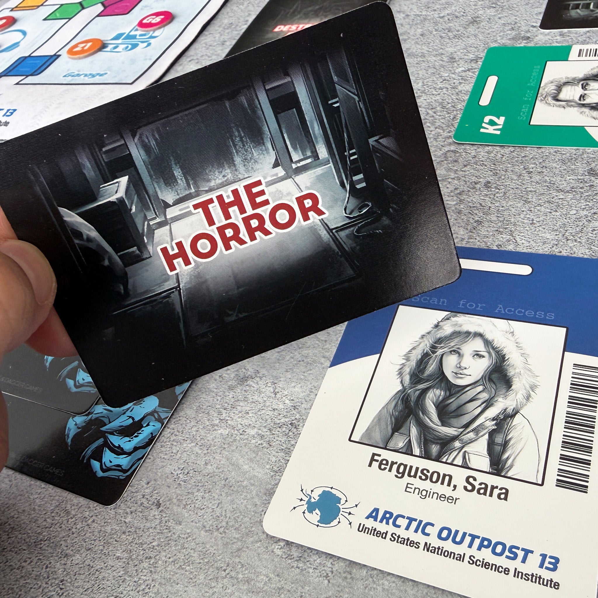 Card with 'The Horror' text held over a card featuring a person named Ferguson, Sara from Arctic Outpost 13.